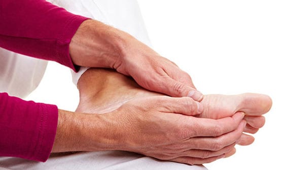 Man holding foot due to inner pain above the arch from accessory navicular syndrome.