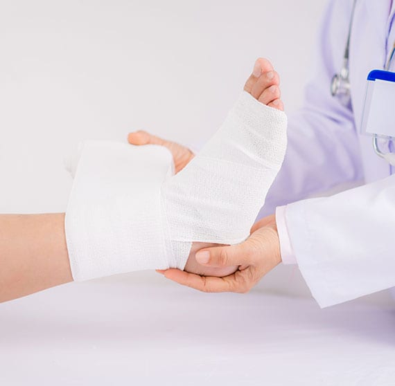 Physician wrapping a foot recovering from trauma.
