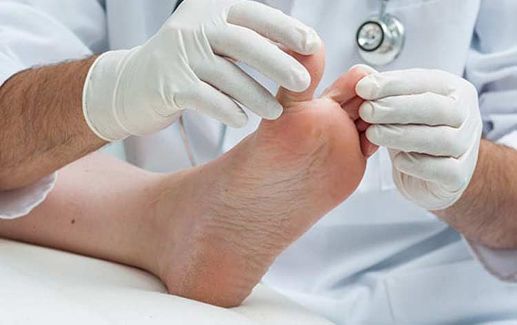 Specialist examining foot before shock wave treatment.