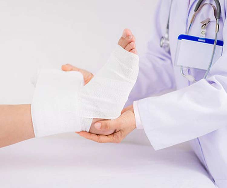 Physician treating foot with fracture injury.
