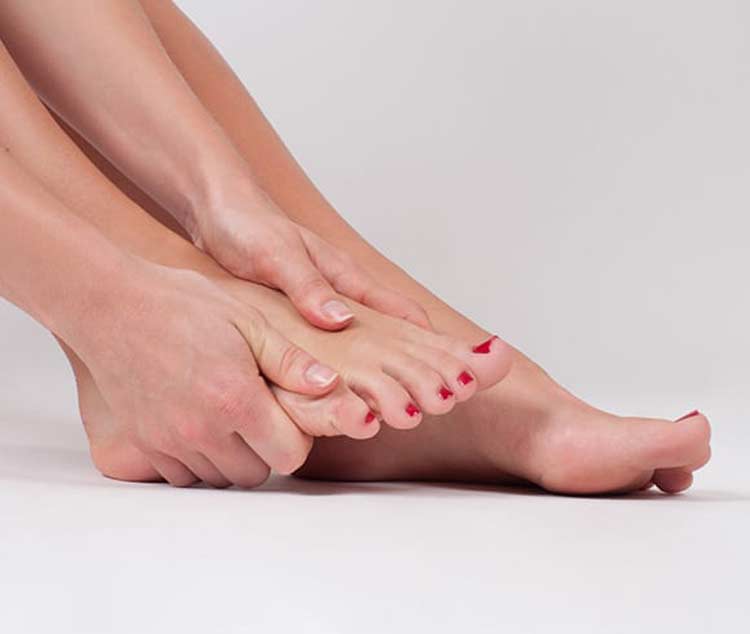 Female dealing with foot pain because of ganglions.