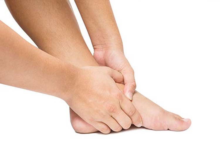 Person holding foot because of pain from Lisfranc joint injury.